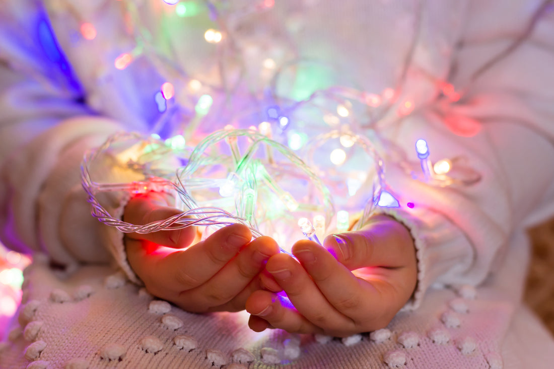 Hands holding colorful LED string lights, illustrating safe connection tips for beautiful holiday lighting and festive home decor.